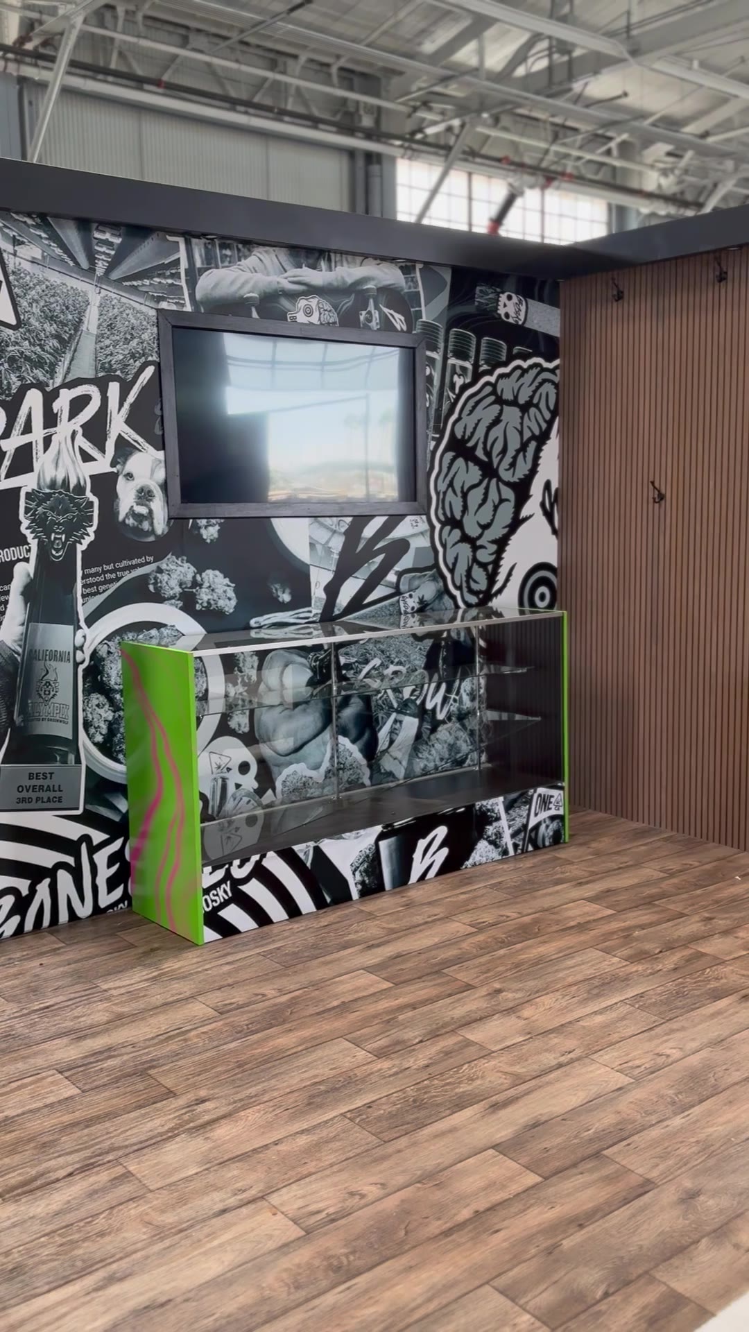 TV recessed into the black-and-white mural wrap, display case below